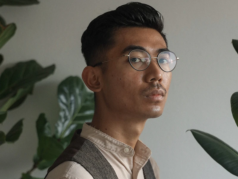 Vinhay Keo's Headshot with a green plant in the background